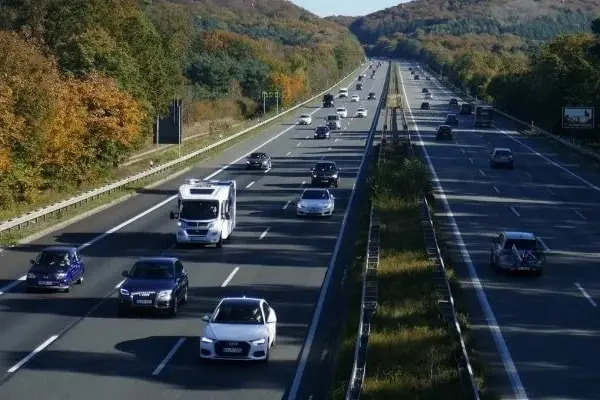 Ein Auto wird außerorts von einem mobilen Blitzer erfasst, ein rotes Licht leuchtet kurz auf.